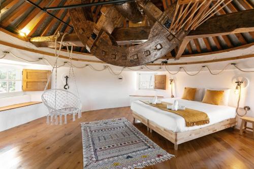 Un dormitorio con una cama, una mesa y una silla. en Moinho do Sr. Arnaldo, en Atouguia da Baleia