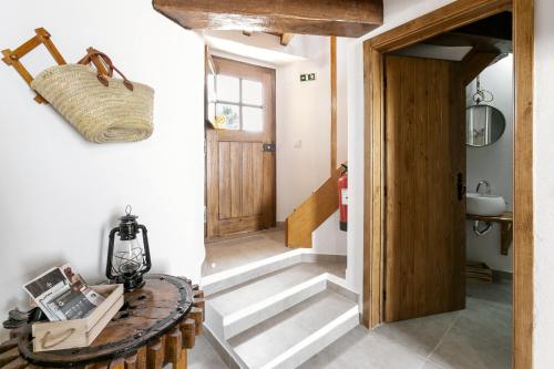 pasillo con puerta de madera y escalera en Moinho do Sr. Arnaldo, en Atouguia da Baleia