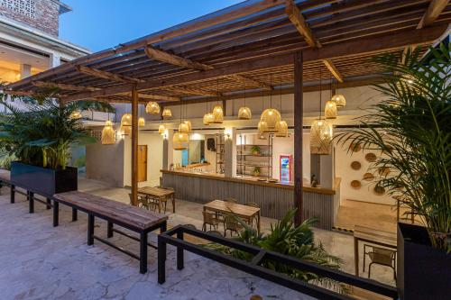 a patio with benches and tables and a restaurant at Soy Local Santa Marta in Santa Marta