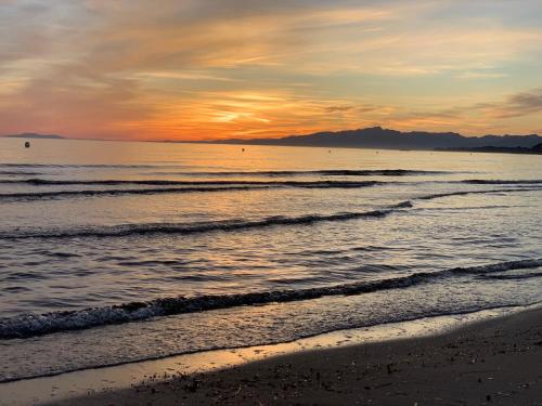 a sunset on the beach with the ocean at SOLIMAR 10 SALOU Solo FAMILIAS con Parking y piscina in Salou