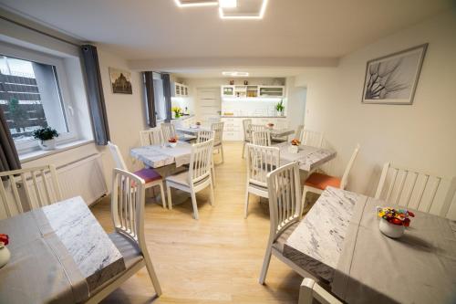 a dining room with tables and chairs and a kitchen at Apartamenty Wisła Centrum in Wisła