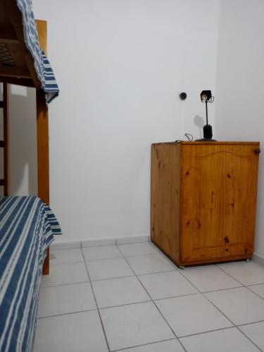 1 dormitorio con armario de madera junto a la cama en Casa Guevara en San Rafael