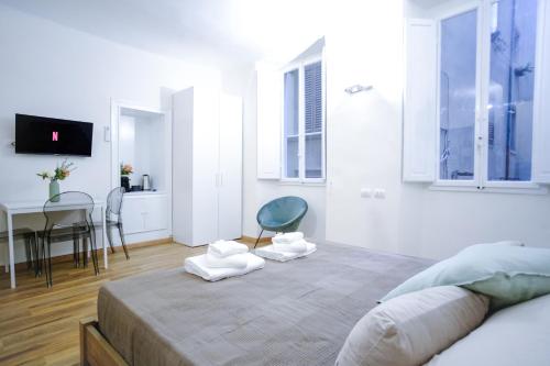 een slaapkamer met een bed, een tafel en een stoel bij Le Dantesche Boutique Apartments in Florence