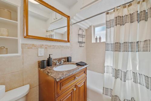 a bathroom with a sink and a shower curtain at the Lucerne in Lake Worth
