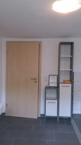 a room with a door and a desk and a shelf at Ferienwohnung im bayerischen Wald in Tittling