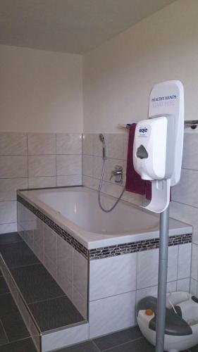 a bathroom with a bath tub and a hair dryer at Ferienwohnung im bayerischen Wald in Tittling