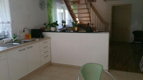 a kitchen with a sink and a counter with a staircase at Ferienwohnung im bayerischen Wald in Tittling