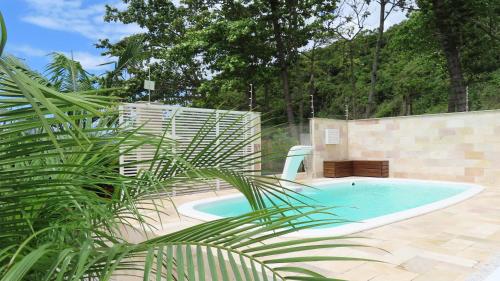 una piscina con una palmera al lado en MarLuar Casa, en Penha