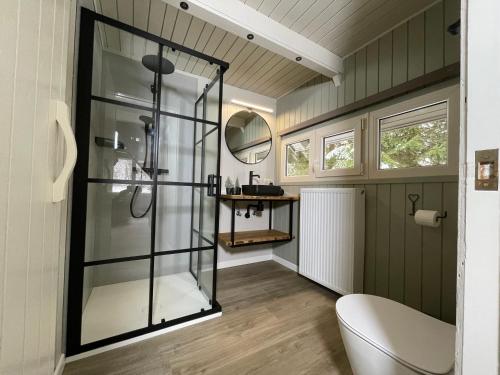 a bathroom with a glass shower and a toilet at Charme à Graide in Graide