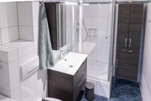 a white bathroom with a sink and a shower at Stilvolles 50qm Altstadt Apt Ingolstadt in Ingolstadt