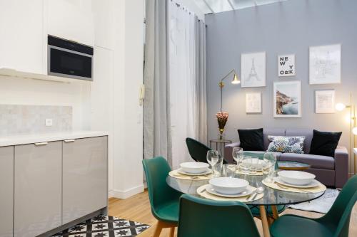 ein Esszimmer mit einem Tisch und grünen Stühlen in der Unterkunft GuestReady - Cosy Apartment near the Invalides in Paris
