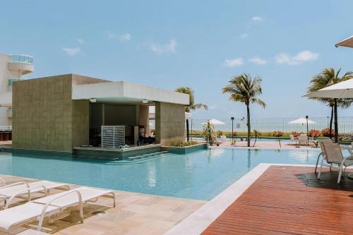 a swimming pool with chairs and a building at In Mare Bali Resort Beira Mar by Qavi - 109 in Parnamirim