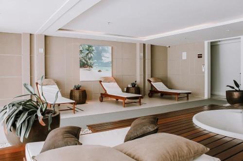 a living room with chairs and a couch and a tub at In Mare Bali Resort Beira Mar by Qavi - 109 in Parnamirim