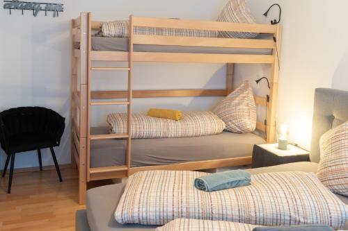 a room with three bunk beds and a chair at Stilvolles 50qm Altstadt Apt Ingolstadt in Ingolstadt