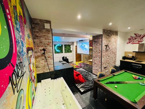 een kamer met een pooltafel en een speelkamer bij Capsule Street Art - Sauna- Jacuzzi - Playstation 5 - Billard - Netflix - Home cinéma - Terrasse in Douai