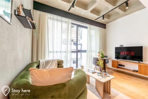 een woonkamer met een groene bank en een televisie bij Stayhere Casablanca - Gauthier 1 - Modern Residence in Casablanca