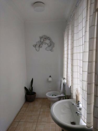 a white bathroom with a toilet and a sink at loft 33 in Pietermaritzburg