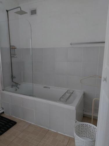 a white bathroom with a tub and a glass shower at loft 33 in Pietermaritzburg