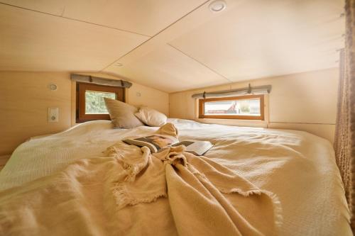 a woman laying on a bed in a room at Tiny House Örebro in Örebro