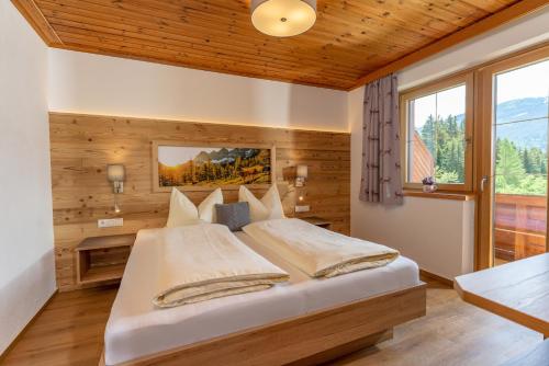um quarto com uma cama num quarto com paredes de madeira em Pircherhof Appartements em Haus im Ennstal