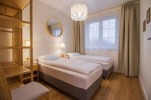 a hotel room with two beds and a window at Wiśniowy Sad - Domki in Białowieża