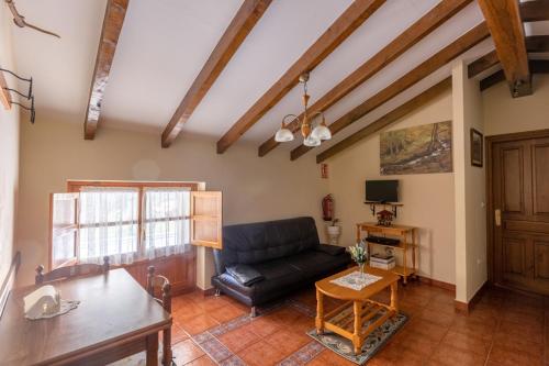 a living room with a couch and a table at Apartamentos Rurales Villa-García in Corigos