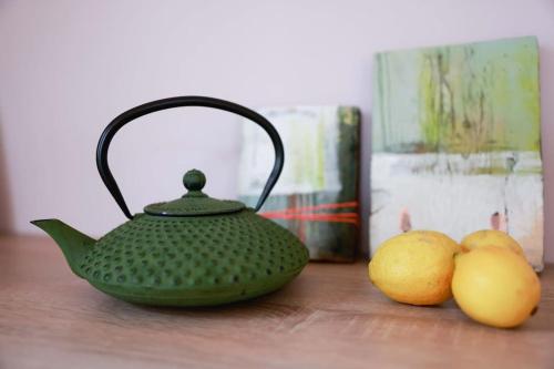 a green tea kettle and two lemons on a wooden table at hej atelier Ferienwohnung in Heiligenthal
