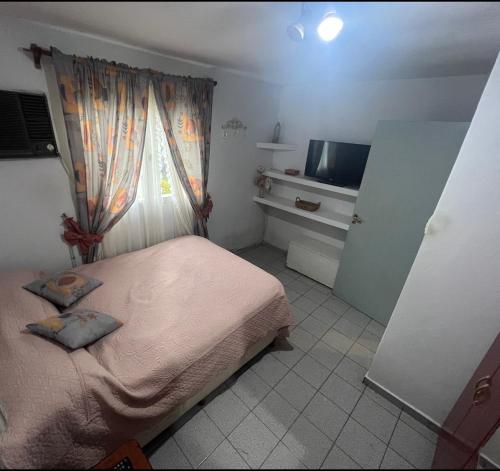 Habitación pequeña con cama y ventana en CASA EN VILLA DE MERLO ( san Luis ) en Merlo