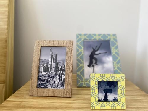 a table with two picture frames and a picture of a person at Apartamento Park Way Bogotá in Bogotá