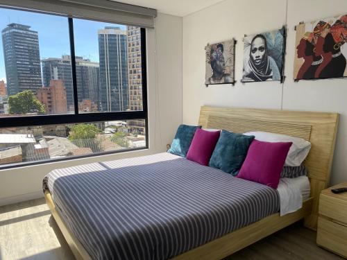 a bedroom with a bed and a large window at Apartamento Park Way Bogotá in Bogotá