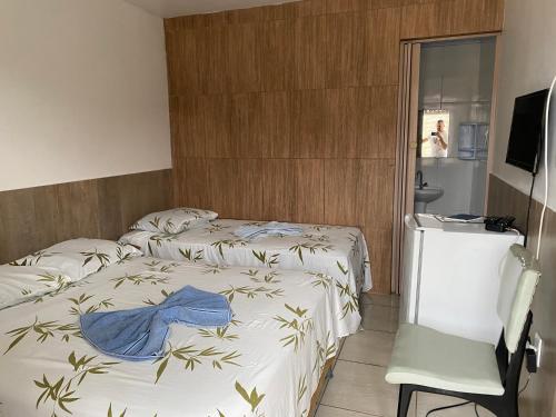 um quarto de hotel com duas camas e uma televisão em Pousada Savoya em Ilhéus