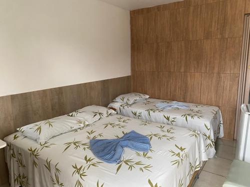 duas camas num quarto de hotel com dois lençóis azuis em Pousada Savoya em Ilhéus