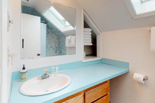 a bathroom with a sink and a mirror at Newport's Cypress Oceanview Home in Newport