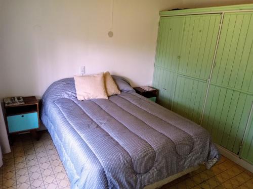 uma cama num quarto com paredes verdes e brancas em Casa mora! em Neuquén