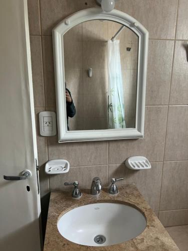 a person taking a picture of a bathroom sink at Cerro Arco Apart Hotel in El Challao