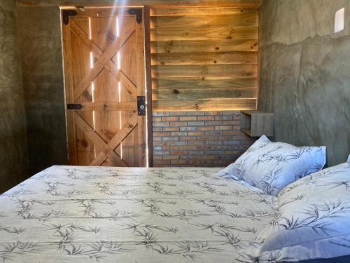 a bedroom with a bed and a wooden door at Pousada Nascer da Lua in Fortim