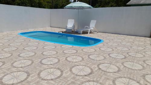 uma piscina com duas cadeiras e um piso de azulejo em CHALÉ ESTÂNCIA OURO VERDE em Lages