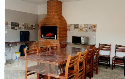 a dining room with a table and a brick fireplace at Royal-inn SPA & Pousada in Itanhaém