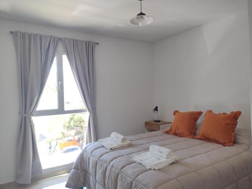 1 dormitorio con 1 cama grande y toallas. en Departamento Caleta View en Puerto Madryn