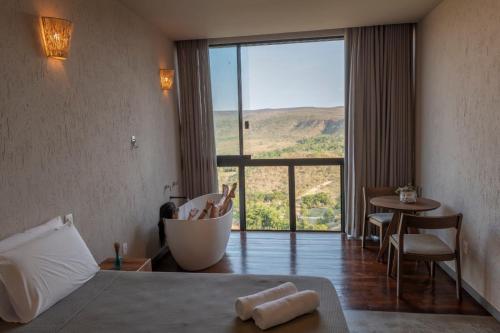 a hotel room with a bed and a large window at Vila Toá in Alto Paraíso de Goiás