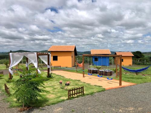 einen Spielplatz mit Schaukel und ein Haus in der Unterkunft Pousada Pôr do Sol in São João Batista do Glória