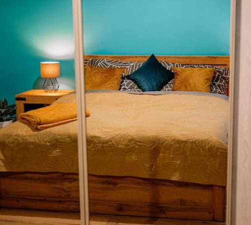 a bedroom with a large wooden bed with a mirror at Apartament blisko Czarnej Góry in Stronie Śląskie