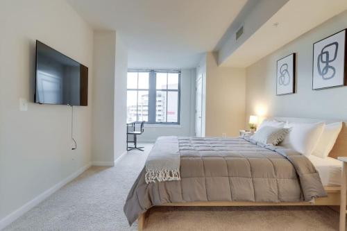 a bedroom with a large bed and a flat screen tv at Spectacular 1BR Condo Located At Pentagon City in Arlington