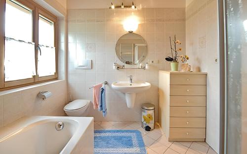 a bathroom with a tub and a sink and a toilet at Appartements Karbon in Seiser Alm