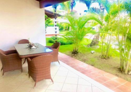a patio with a table and chairs and palm trees at Tamarindo in Bayahibe