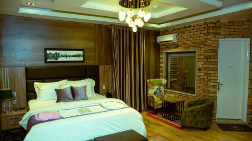 um quarto com uma cama e uma parede de tijolos em TN MAX LUXURY HOME em Enugu