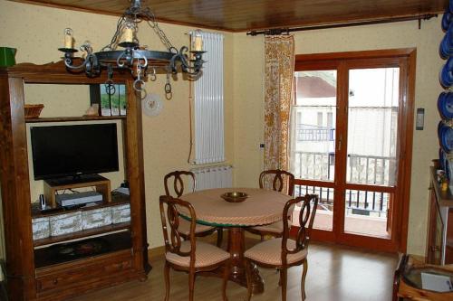 a dining room with a table and chairs and a television at Casa vacanze Rocca in Roccaraso