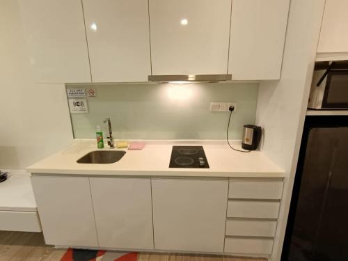 a white kitchen with a sink and a stove at The Perfect Retreat @One Bukit Ceylon (UNIT 25-2) in Kuala Lumpur