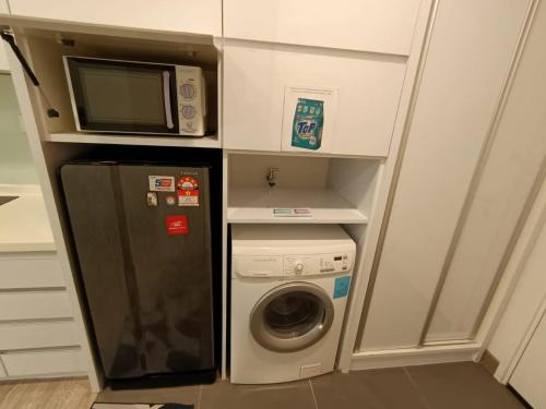 a kitchen with a microwave and a washing machine at The Perfect Retreat @One Bukit Ceylon (UNIT 25-2) in Kuala Lumpur
