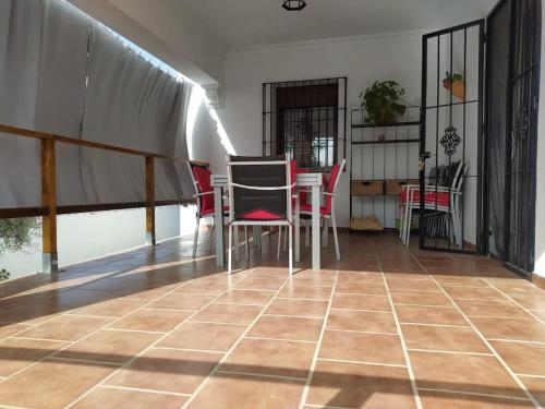 Habitación con mesa, sillas y suelo de baldosa. en Agradable casa con piscina en la serranía. en Arriate